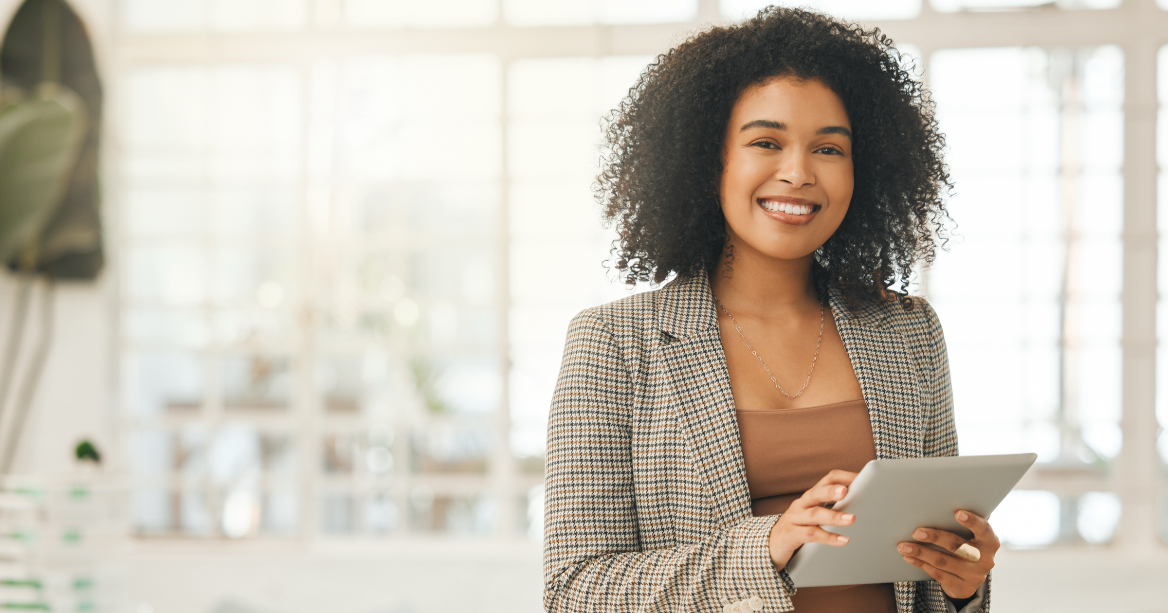 Smiling professional woman with tablet in hand.