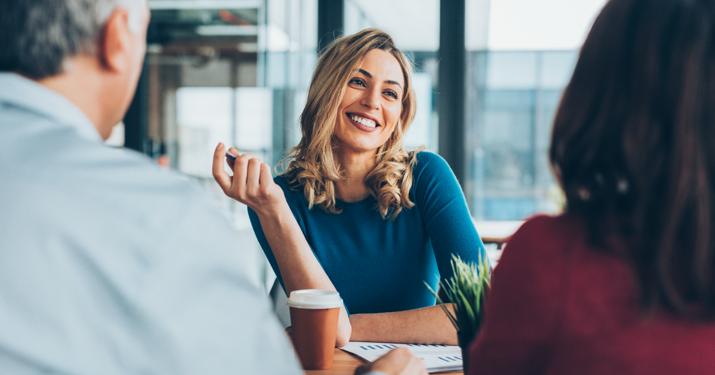 Smiling business woman in meeting with team
